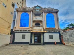 a large building with blue windows on a street at HOTEL GREENS - Puratchi Thalaivar Dr M G Ramachandran Central Railway Station Chennai in Chennai