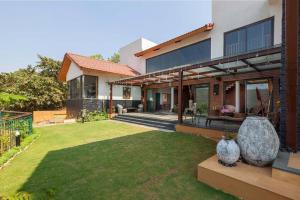 a house with a large rock in the yard at Soul Tree Villa 50 Super Luxury Villa with heated plunge pool and jacuzzi in Lavasa