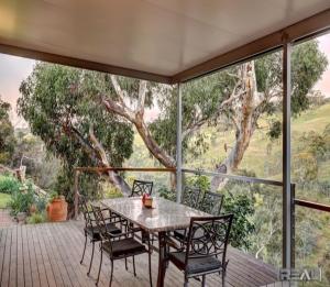 un patio con mesa y sillas en una terraza en HighRoost Bed & Breakfast accomodation - rural escape en Red Creek