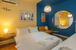 a bedroom with a large white bed and a mirror at Studio Apartments Villa 24 in Tirana