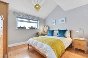 ein Schlafzimmer mit einem Bett mit blauen Kissen und einem Fenster in der Unterkunft Quay House, North Coast 6 bedroom holiday home in Ballycastle
