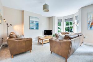 a living room with two couches and a tv at Quay House, North Coast 6 bedroom holiday home in Ballycastle