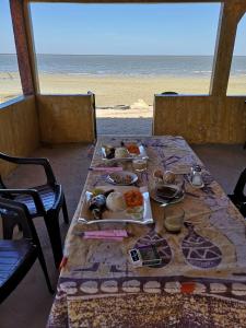una mesa con platos de comida en la playa en Le Figuier, en Pointe-Saint-Georges