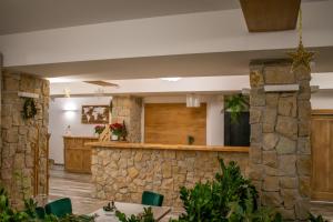 a lobby of a resort with a stone wall at Vale Humor Residence in Mănăstirea Humorului