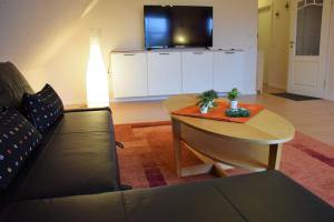 sala de estar con sofá, mesa y TV en Lindensweet en Lindwedel