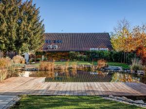a garden with a pond in front of a building at Wellness Hotel Volarik in Mikulov