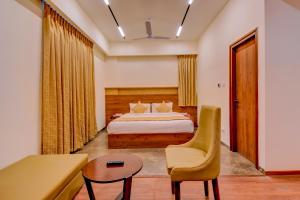 a bedroom with a bed and a chair and a table at Zip By Spree Hotels Brookefield in Bangalore +38 photos