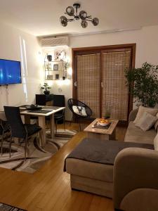- un salon avec un canapé et une table dans l'établissement Ivy Apartment, à Vrnjačka Banja