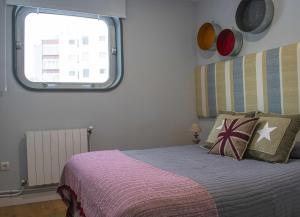 Apartamento Dúplex Estación Manzaneda في أورينس: غرفة نوم بسرير ونافذة
