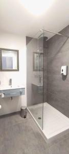 La salle de bains est pourvue d'une douche avec une porte en verre. dans l'établissement Apartamento Dúplex Estación Manzaneda, à Ourense