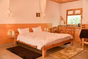 - une chambre avec un grand lit et un lavabo dans l'établissement The Naturewalk, à Mukteswar
