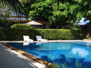 una piscina con due sedie e un ombrellone di Andaman Resort a Phi Phi Don
