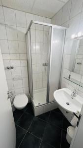 a bathroom with a shower and a toilet and a sink at Creativ Park Hotel in Nuremberg