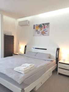 Un dormitorio blanco con una cama con toallas. en Modern stylish apartments on Lazurna Street in the RC Riviera overlooking the river en Mykolaiv
