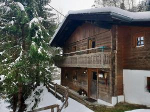 a log cabin with a balcony in the snow at Almliesl EMBA-605 in Embach
