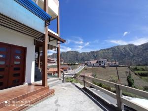 a house with a balcony with a view of the mountains at Bromo Deddy Homestay in Bromo