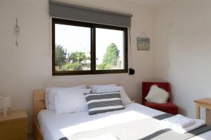 a bedroom with a white bed and a window at Guest Apartments in Limassol