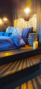 un letto con lenzuola blu e una candela e luci di Accessible Luxury a Artemida