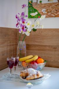 a table with a bowl of fruit and a vase with flowers at IL CENTRO LUXURY SUITES in Bari +35 photos