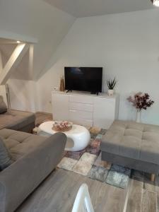 a living room with a couch and a tv at Valentin Apartman in Makó