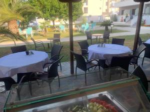 ケラモティにあるAphroditeのレストランには2つのテーブルと椅子があり、フルーツを1杯用意しています。