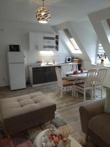 a kitchen and a living room with a table and chairs at Valentin Apartman in Makó