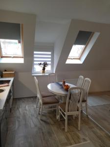 a kitchen with a table and chairs and skylights at Valentin Apartman in Makó