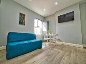 a living room with a blue couch and a table at Stunning property fully refurbished in Birmingham