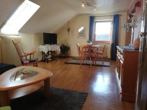 弗拉敦根的住宿－Ferienwohnung Haus Silvia，客厅配有桌椅和电视。