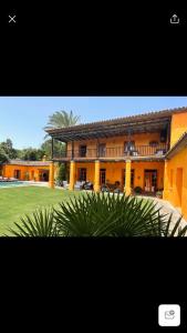 a large yellow building with a palm tree in front of it at La Dulcinea in Sotogrande