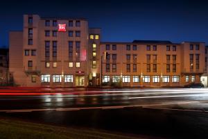 a building with a red sign on it next to a street at ibis Bremen City in Bremen