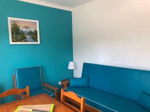 a living room with a blue couch and a table at Camping Villa Park Zambujeira do Mar in Zambujeira do Mar
