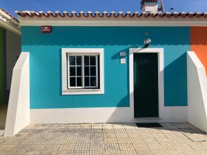 a colorful house with a door and a window at Camping Villa Park Zambujeira do Mar in Zambujeira do Mar