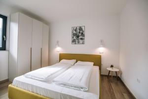 ein Schlafzimmer mit einem großen Bett mit weißer Bettwäsche in der Unterkunft Apartma EVA Golte in Mozirje