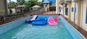 a pool with four inflatable toys in the water at PhaGibs Inn Hotel in Freetown