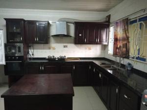 una cucina con armadi in legno e piano di lavoro di PhaGibs Inn Hotel a Freetown