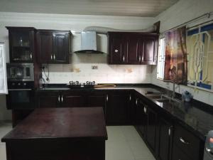 a kitchen with wooden cabinets and a counter top at PhaGibs Inn Hotel in Freetown