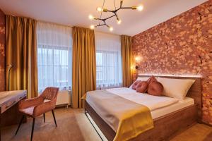 1 dormitorio con 1 cama grande y 1 silla en Hotel Alfréd a Hermína en Olomouc