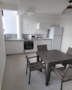 a kitchen with a table and chairs in a kitchen at Hello Guyane (2), Suite Luxury, 5 étoiles in Cayenne