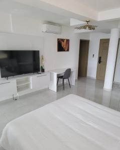 a white living room with a television and a table at Hello Guyane (2), Suite Luxury, 5 étoiles in Cayenne