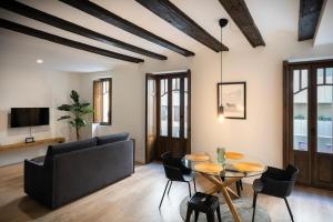 Una sala de estar con un sofá, una mesa y sillas. en Total Valencia Ayuntamiento, en Valencia