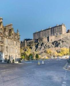 a large building in front of a castle at Castle Terrace 1 Bed Apartment Looking onto Edinburgh Castle - Sleeps upto 4 in Edinburgh