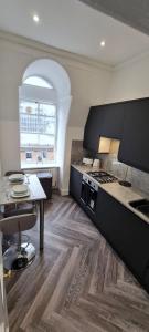 a kitchen with a stove and a table in a room at Castle Terrace 1 Bed Apartment Looking onto Edinburgh Castle - Sleeps upto 4 in Edinburgh