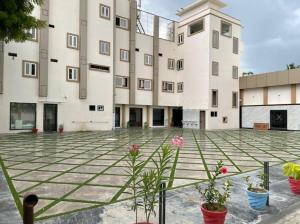 an empty courtyard with potted plants in front of a building at Paras Mahal in Vellore