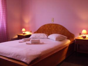a bedroom with a bed with two towels and two lamps at Villa Katerina Holiday Apartments in Sitia