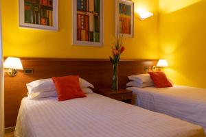 2 camas en una habitación con paredes amarillas en Hotel New Genziana, en Altavilla Vicentina
