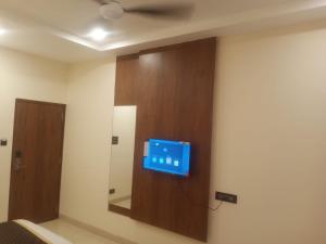 a television on a wall in a room at Paras Mahal in Vellore