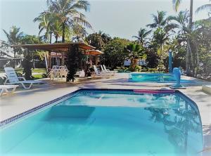 a swimming pool with blue water in a resort at Pousada Aldeia Portuguesa in Porto Seguro