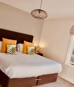 a bedroom with a large bed with orange and white pillows at Penny Black Cottage in Coalbrookdale