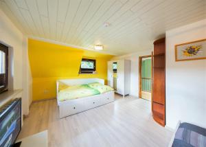 ein Schlafzimmer mit einem Bett mit gelber Wand in der Unterkunft Ferienhaus Angela in Hameln